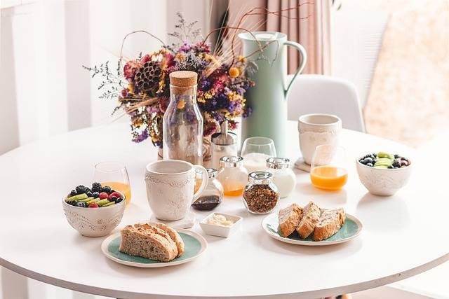 Table de petit-déjeuner dressée avec pain, café et fruits frais