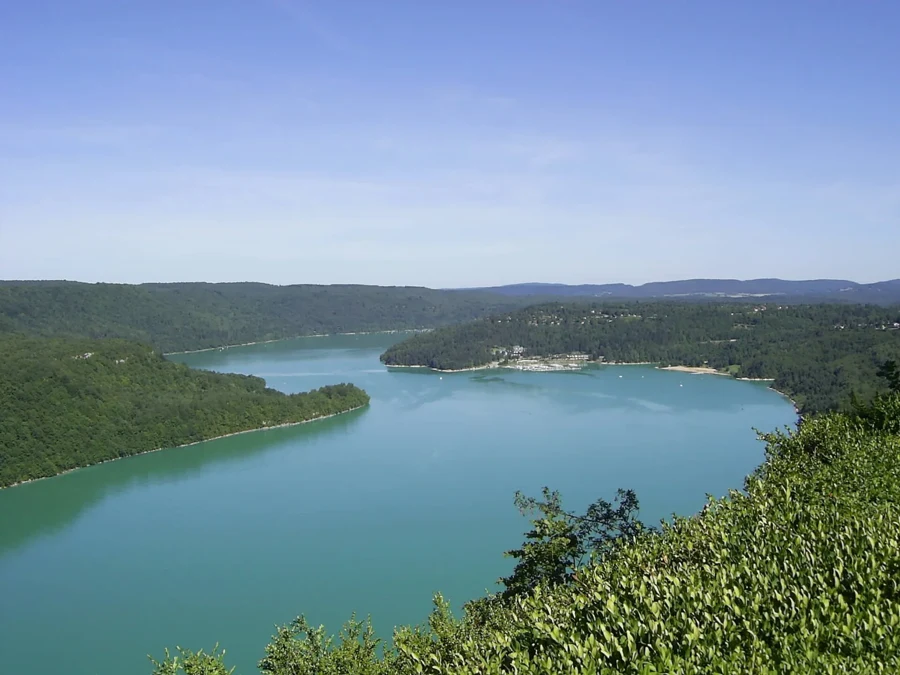 Vue sur le lac de Vouglans entouré de forêts, au creux d&rsquo;une vallée du Jura