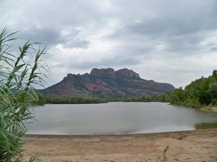 Le rocher de Roquebrune dominant le lac de l'Aréna, avec sa plage de sable